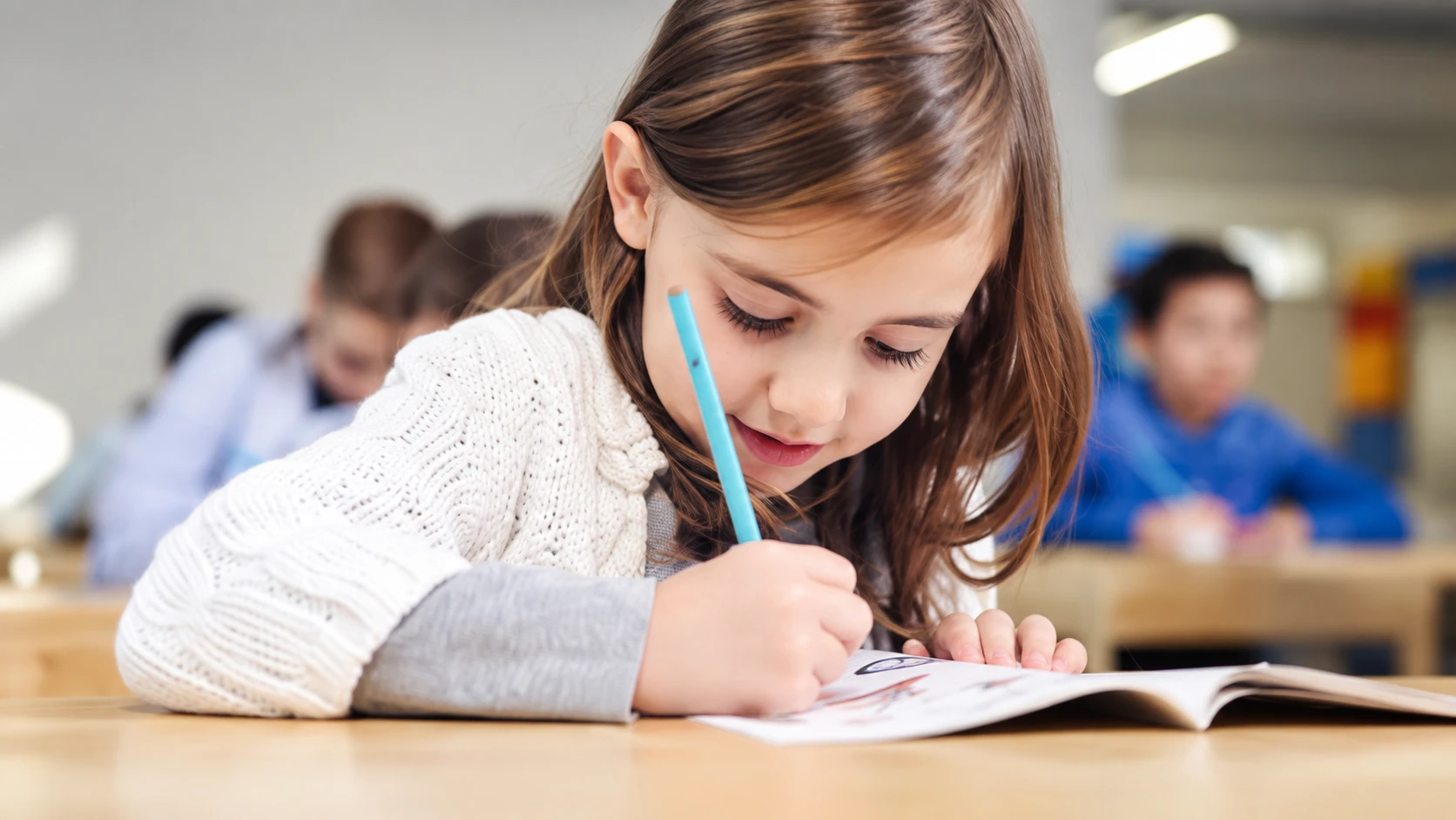 A schoolgirl writes in her workbook in a classroom
