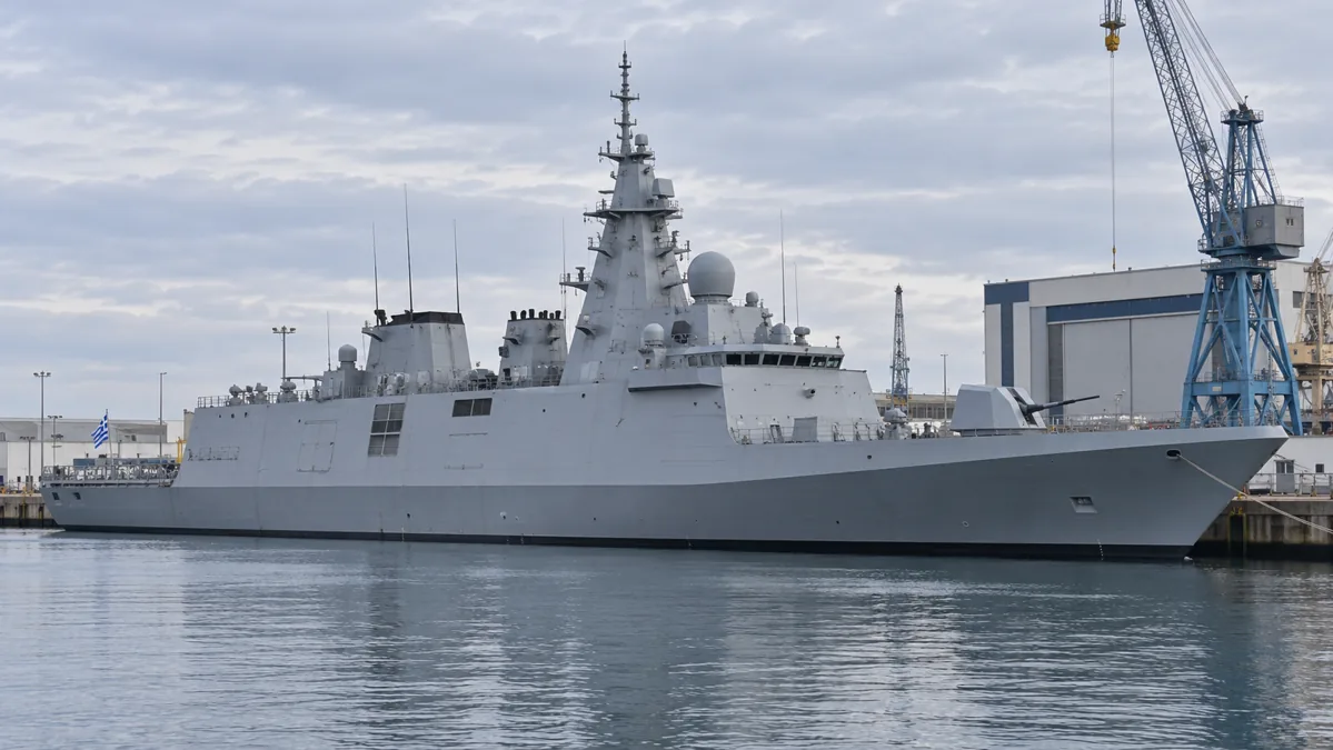 Modern frigate in a shipyard harbour