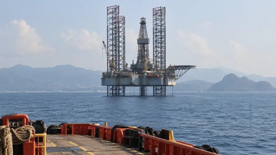 Offshore drilling platform on a calm sea, seen from a vessel deck